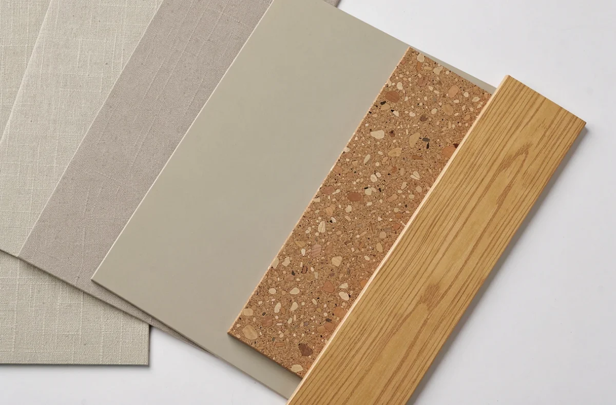 Échantillons de revêtements intérieurs variés disposés en éventail sur une table blanche