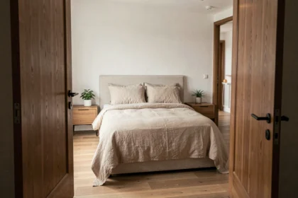 Chambre moderne avec lit face à la porte ouverte, vue depuis l'entrée
