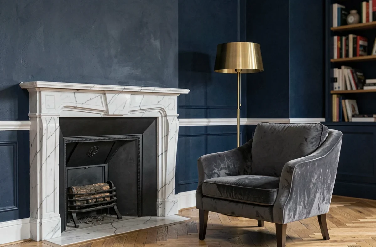 Salon de style parisien avec murs bleu marine profond, moulures blanches et cheminée en marbre illustrant une couleur de mur élégante pour un salon raffiné